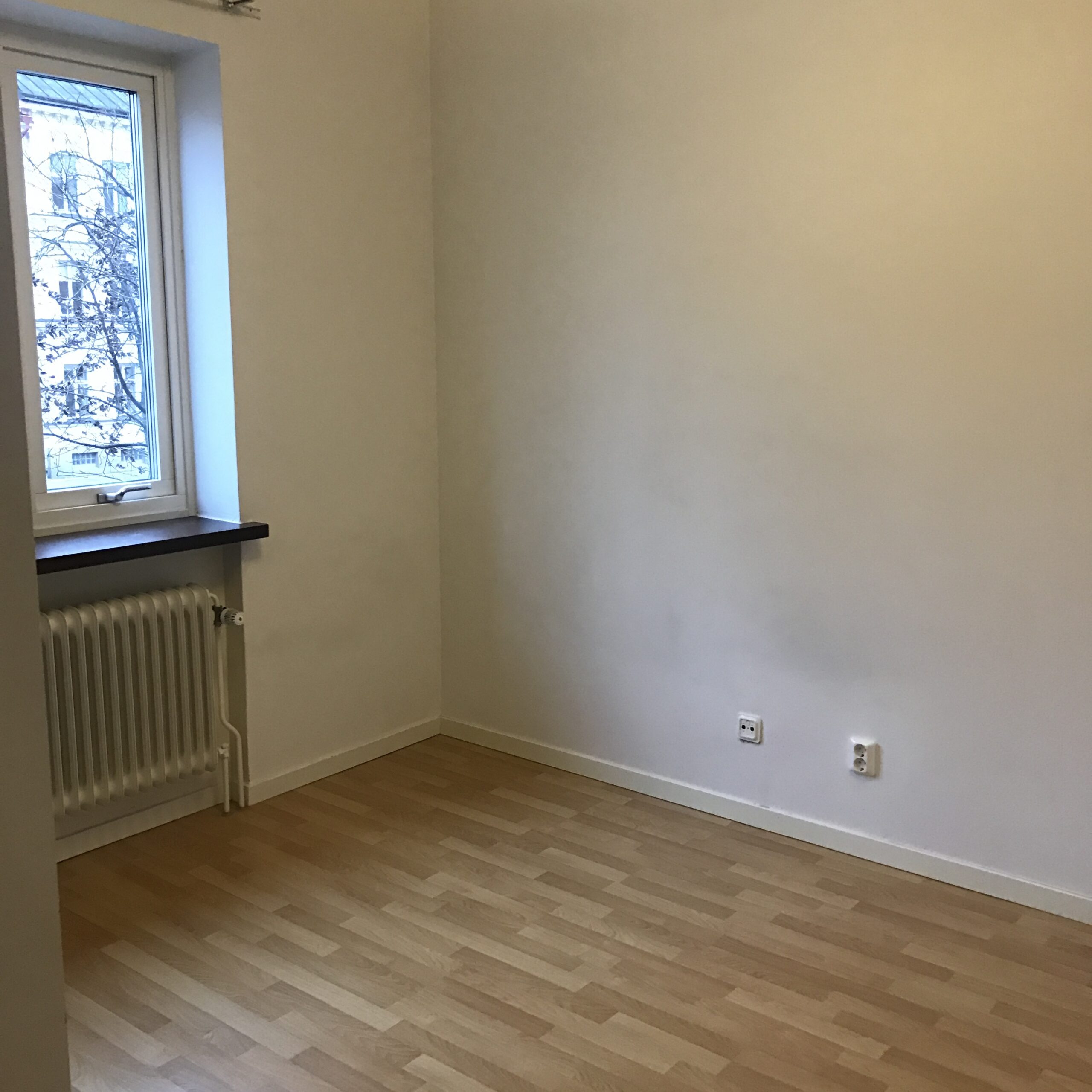 Vit hall med trägolv med passager till kök och vardagsrum  i Halmstad