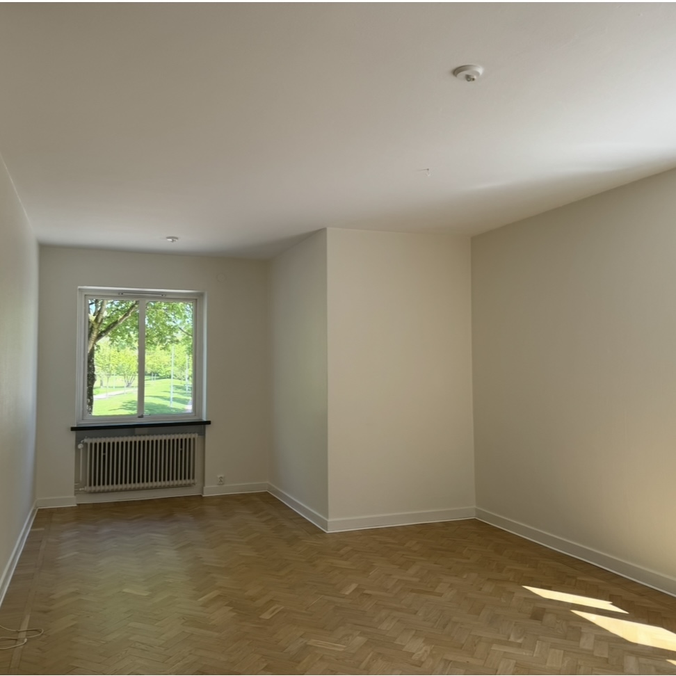 Vit hall med trägolv med passager till kök och vardagsrum  i Halmstad