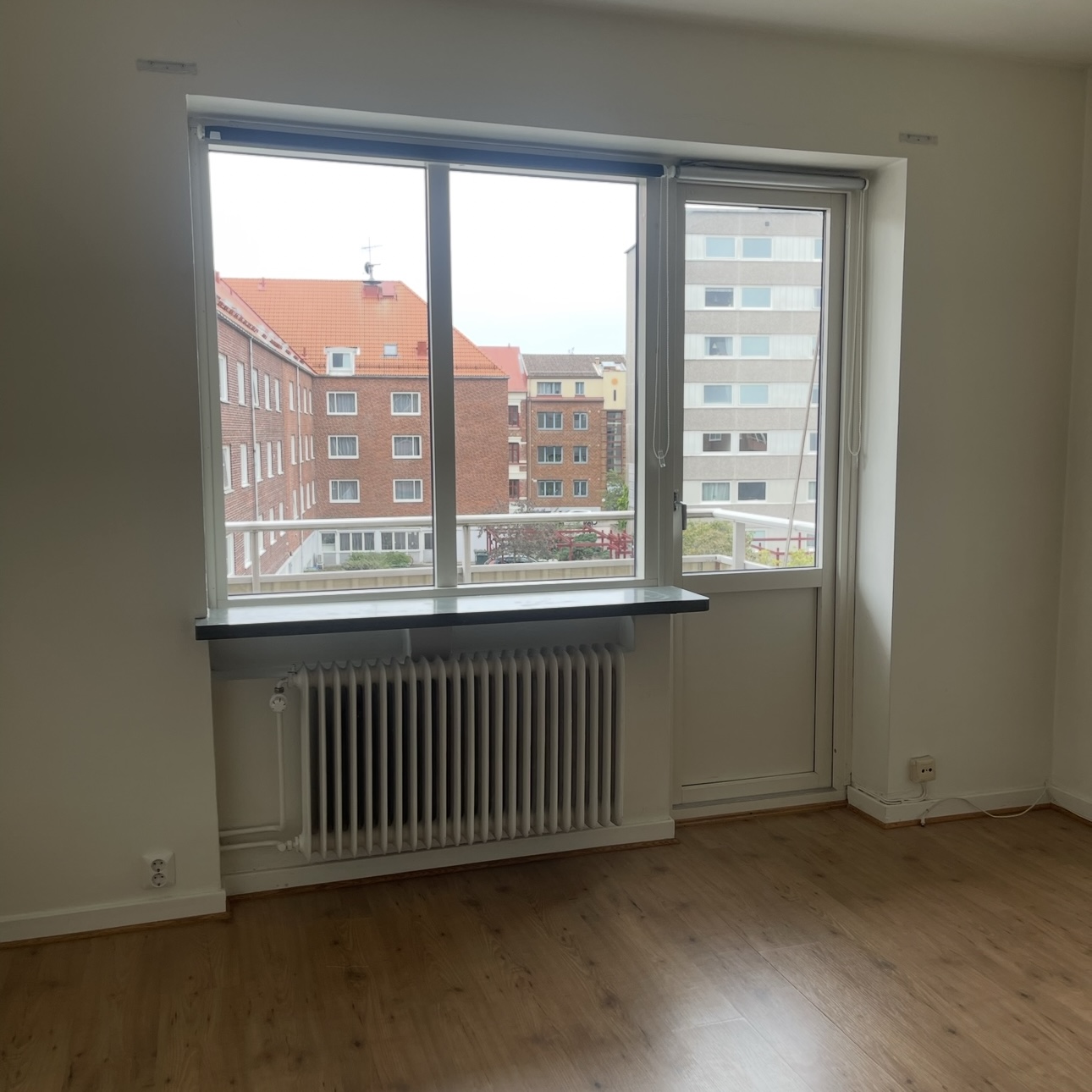 Vit hall med trägolv med passager till kök och vardagsrum  i Halmstad