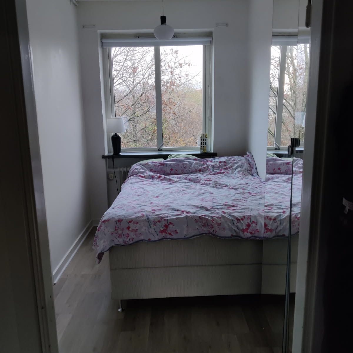 Vit hall med trägolv med passager till kök och vardagsrum  i Halmstad